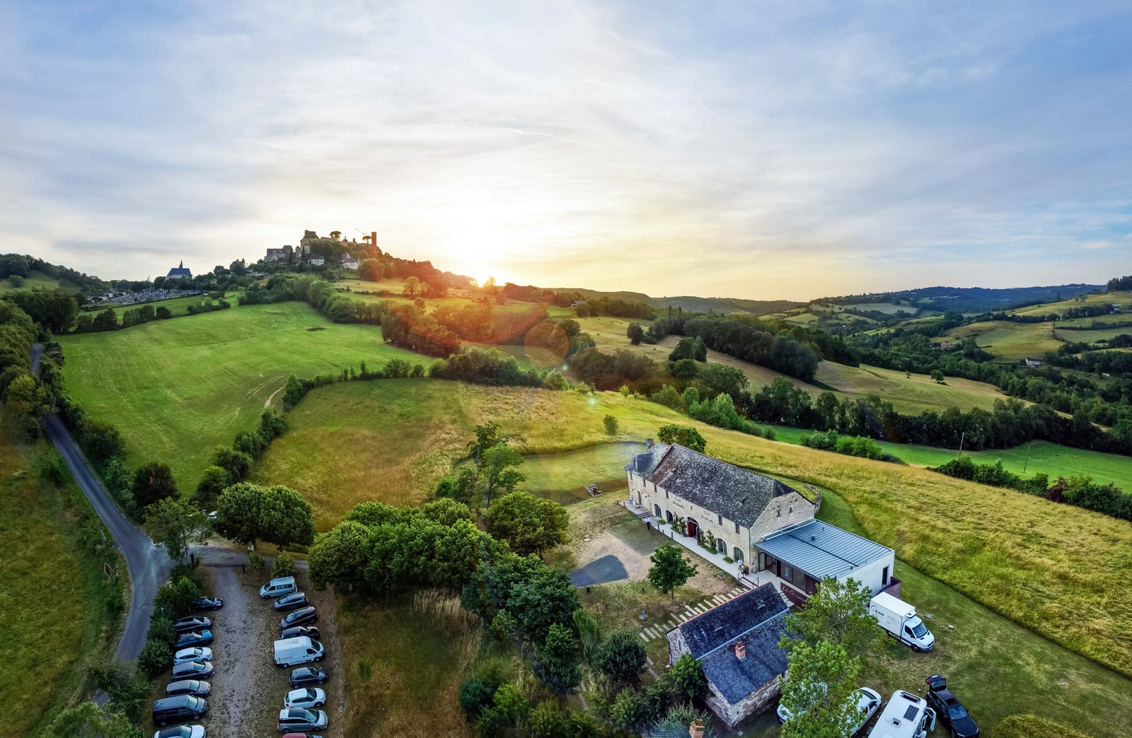 Vue aérienne du domaine au coucher du soleil, le village perché se découpant à l'horizon