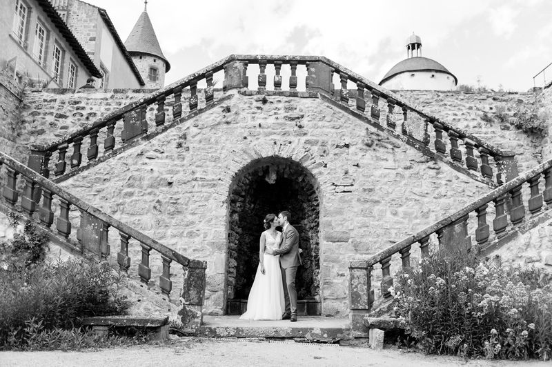 Mariés s'embrassant sous l'arche d'un escalier de pierre, noir et blanc, château de Beauvoir en Auvergne